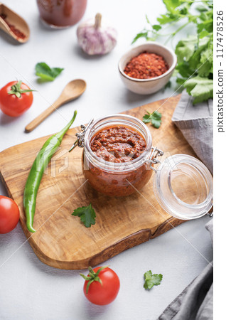 Homemade tomato sauce for pizza or pasta in a jar on a wooden board on a light background Homemade tomato sauce for pizza or pasta in a jar on a wooden board on a light background 117478526