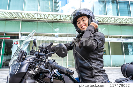 Image cut of a female rider touring Yokohama on a large cruiser bike Image cut of a female rider touring Yokohama on a large cruiser bike 117479032