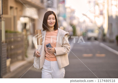 一個穿著半外套去購物的中年婦女 117480518