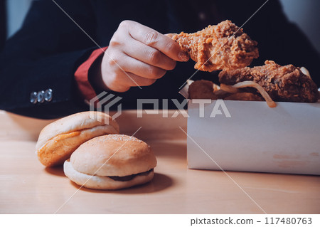 close up focus woman hand hold fried chicken for eat,girl with fast food concept close up focus woman hand hold fried chicken for eat,girl with fast food concept 117480763
