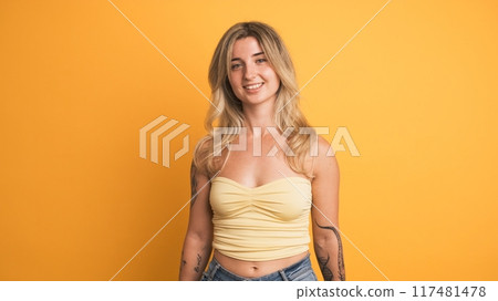 Chilling young woman standing against yellow background Chilling young woman standing against yellow background 117481478