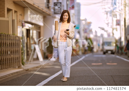 A middle-aged woman wearing a half coat going shopping 117481574
