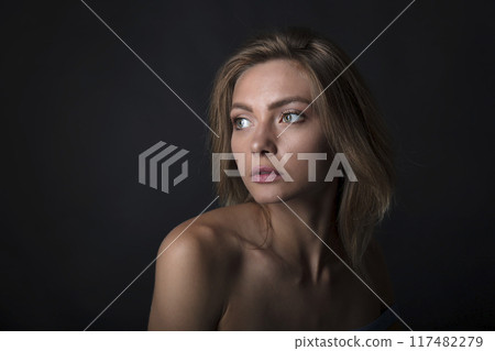 portrait of a young attractive woman on a dark background 117482279