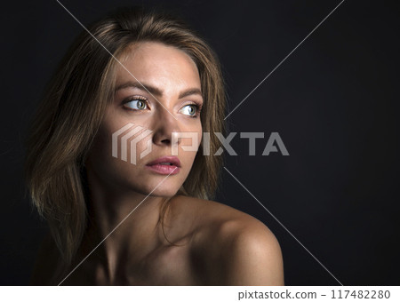 portrait of a young attractive woman on a dark background 117482280