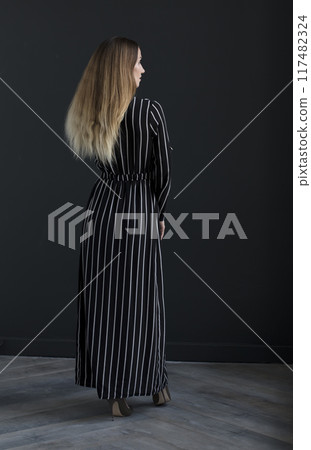 young beautiful woman on a dark background, full length studio shot 117482324