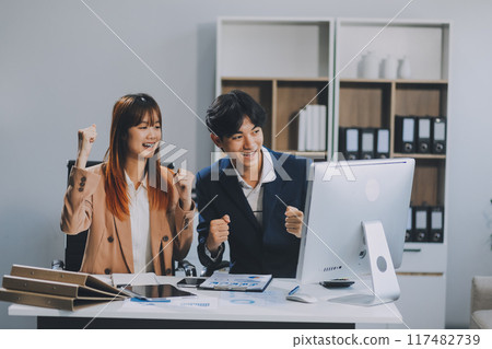 Entrepreneur Asian businessman and businesswoman discussing new business project in tablet in modern Meeting In Modern Office, Asian business casual concept. 117482739