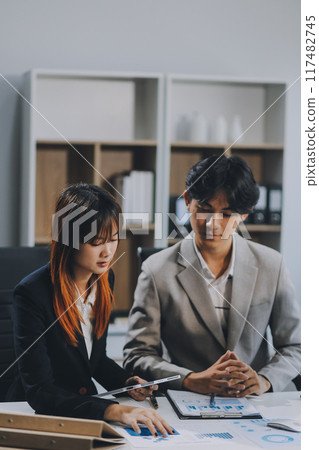 Entrepreneur Asian businessman and businesswoman discussing new business project in tablet in modern Meeting In Modern Office, Asian business casual concept. Entrepreneur Asian businessman and businesswoman discussing new business project in tablet in modern Meeting In Modern Office, Asian business casual concept. 117482745