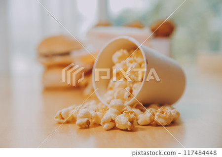 A bucket of popcorn, top-view, warm colors, light brown wooden background, flat lay, daylight macro close-up A bucket of popcorn, top-view, warm colors, light brown wooden background, flat lay, daylight macro close-up 117484448