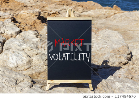 Market volatility symbol. Concept words Market volatility on beautiful black chalk blackboard. Chalkboard. Beautiful stone sea sky background. Business market volatility concept. Copy space.orange 117484670