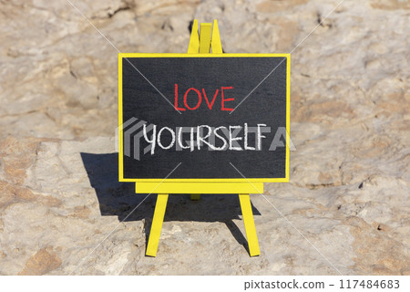 Love yourself symbol. Concept words Love yourself on beautiful black chalk blackboard. Beautiful red stone background. Psychology love yourself concept. Copy space. 117484683