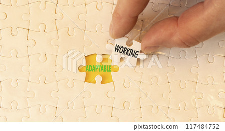 Adaptable working symbol. Concept words Adaptable working on beautiful white paper puzzles. Beautiful yellow background. Businessman hand. Business Adaptable working concept. Copy space. 117484752