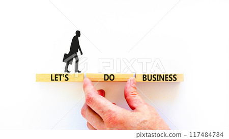 let is do business symbol. Concept words let is do business on beautiful wooden blocks. Beautiful white table white background. Businessman hand. let is do business concept. Copy space. 117484784