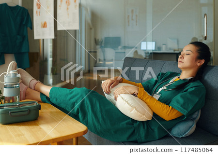 Relaxing Nurse Resting During Break on Comfortable Couch Relaxing Nurse Resting During Break on Comfortable Couch 117485064