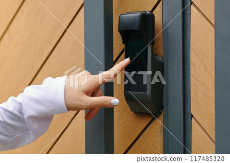 Hand Pressing Digital Door Lock on Wooden Gate Hand Pressing Digital Door Lock on Wooden Gate 117485328