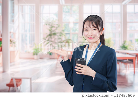 Young business woman drinking coffee in the office Young business woman drinking coffee in the office 117485609
