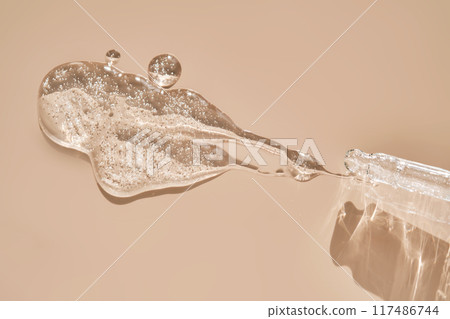 Pipette with cosmetic hyaluronic anti-aging serum on a dusty pink background. Pipette with cosmetic hyaluronic anti-aging serum on a dusty pink background. 117486744