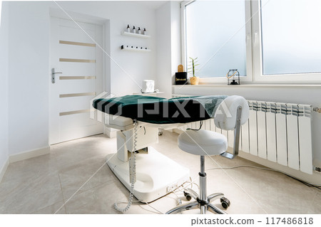 A medical office with a green table and white chairs. The room is clean and well-lit. A medical office with a green table and white chairs. The room is clean and well-lit. 117486818