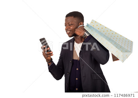 young smiling man with shopping bags is using a mobile phone young smiling man with shopping bags is using a mobile phone 117486971