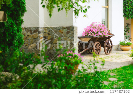 A flower bed in an old wooden cart 117487102