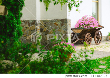 A flower bed in an old wooden cart A flower bed in an old wooden cart 117487104