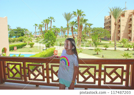 Girls standing on balcony of tropical hotel resort. Child enjoying holidays 117487203