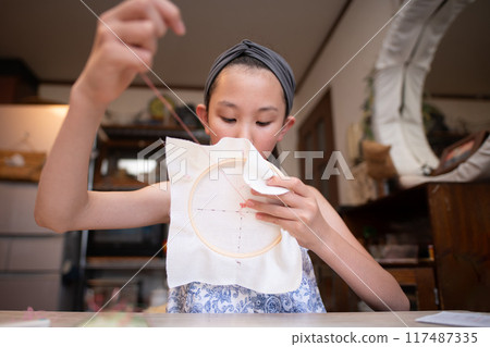 Girl doing embroidery Girl doing embroidery 117487335