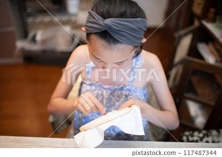 Girl doing embroidery Girl doing embroidery 117487344