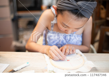 Girl doing embroidery Girl doing embroidery 117487346