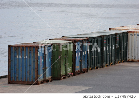 Containers lined up on a pier waiting to be loaded 117487420