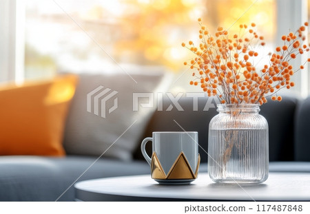 Cozy interior with decorative vase and candle on a table during sunset 117487848