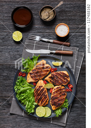 grilled chicken breasts wrapped in bacon on plate grilled chicken breasts wrapped in bacon on plate 117488162