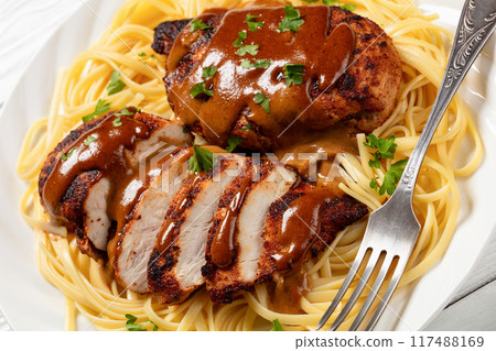 Chicken Lazone with sauce and linguine on plate Chicken Lazone with sauce and linguine on plate 117488169