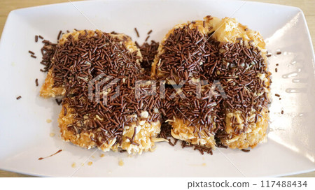 Appetizer or fried banana snack menu topped with grated cheese and chocolate. Appetizer or fried banana snack menu topped with grated cheese and chocolate. 117488434