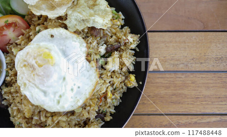Nasi Goreng Kampung or Traditional Indonesian Fried Rice, wok fried rice with chicken, asian green served with egg, sambal and crackers. Nasi Goreng Kampung or Traditional Indonesian Fried Rice, wok fried rice with chicken, asian green served with egg, sambal and crackers. 117488448