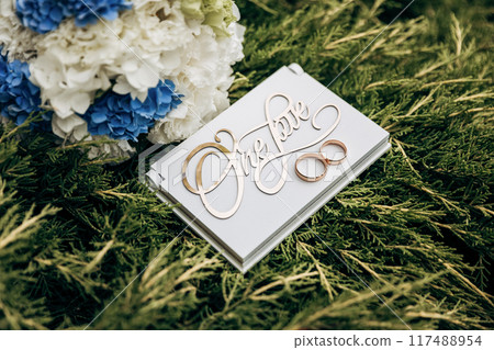 Elegant wedding details with floral bouquet and 'One Love' sign, symbolizing eternal unity Elegant wedding details with floral bouquet and 'One Love' sign, symbolizing eternal unity 117488954