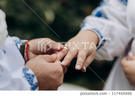 Beautiful close-up of a bride and groom exchanging wedding rings during a romantic ceremony 117488986