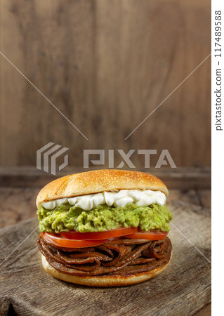 CHILEAN FOOD. Sandwich Churrasco italiano on colors of italian flag. Popular sandwich with round bread, beef, avocado guacamole, tomatoes and mayonnaise 117489588