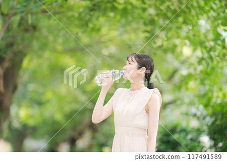 Profile of a woman drinking water from a plastic bottle 117491589
