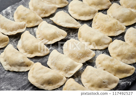 Freshly prepared homemade dumplings ready for cooking, showcasing traditional culinary skills 117492527