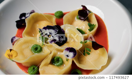 A Gourmet Dish With Stuffed Ravioli And Colorful Creams 117493627