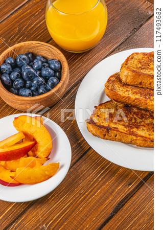 French toast on a plate with blueberries, orange juice, nectarine for breakfast French toast on a plate with blueberries, orange juice, nectarine for breakfast 117493682