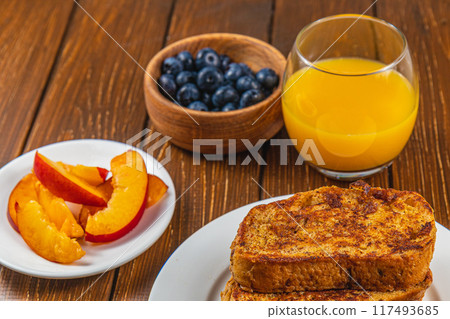 French toast on a plate with blueberries, orange juice, nectarine for breakfast French toast on a plate with blueberries, orange juice, nectarine for breakfast 117493685