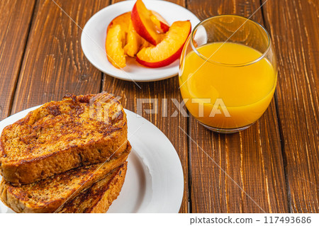 French toast on a plate with blueberries, orange juice, nectarine for breakfast French toast on a plate with blueberries, orange juice, nectarine for breakfast 117493686