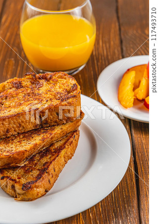 French toast on a plate with blueberries, orange juice, nectarine for breakfast French toast on a plate with blueberries, orange juice, nectarine for breakfast 117493710