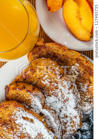 French toast on a plate with blueberries, orange juice, nectarine for breakfast 117493735