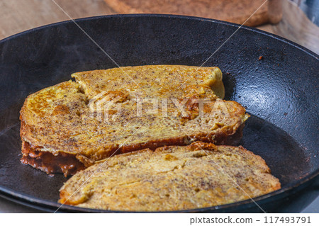 Cooking french toast in a pan on butter 117493791