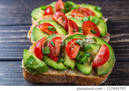 Avocado toast topped with tomato and green onion on a slice of carrot bread Avocado toast topped with tomato and green onion on a slice of carrot bread 117493797
