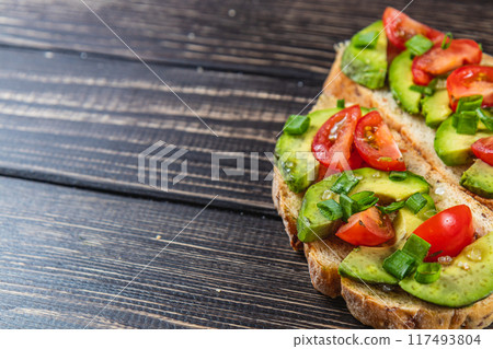 Avocado toast topped with tomato and green onion on a slice of carrot bread Avocado toast topped with tomato and green onion on a slice of carrot bread 117493804