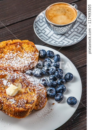 French toast on a white plate with blueberries and coffee for breakfast French toast on a white plate with blueberries and coffee for breakfast 117493805