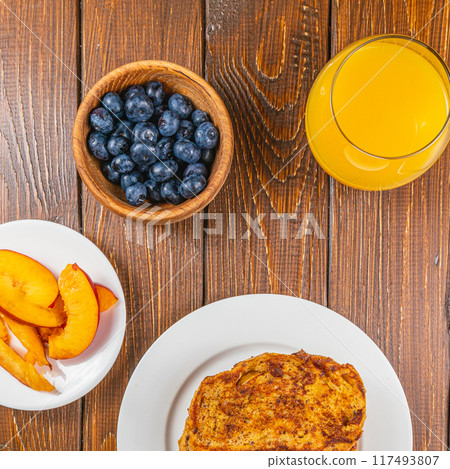 French toast on a plate with blueberries, orange juice, nectarine for breakfast 117493807